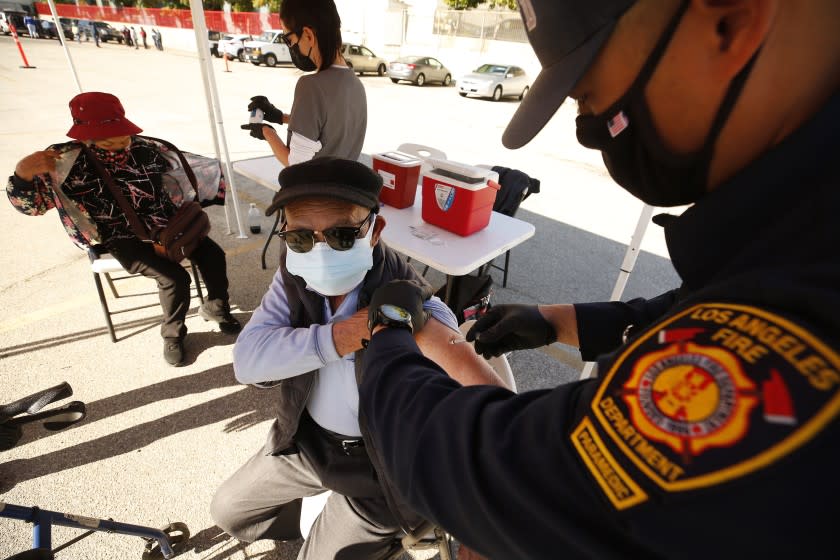 LOS ANGELES, CA - FEBRUARY 24: De An Qu, 81, receives the Pfizer COVID-19 vaccine from LA City Firefighter Paramedic Andrew Huang as the LA City CORE mobile team is staging a COVID-19 vaccination clinic in Chinatown for senior citizens, in an attempt to improve access to the vaccine among vulnerable populations. Chinatown on Wednesday, Feb. 24, 2021 in Los Angeles, CA. (Al Seib / Los Angeles Times).