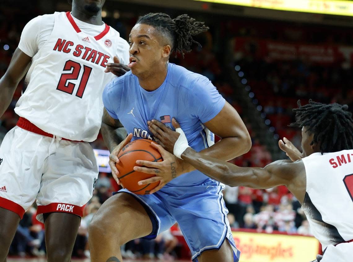 North Carolina’s Armando Bacot (5) drives by N.C. State’s Terquavion Smith (0) during the first half of N.C. State’s game against UNC at PNC Arena in Raleigh, N.C., Sunday, Feb. 19, 2023.