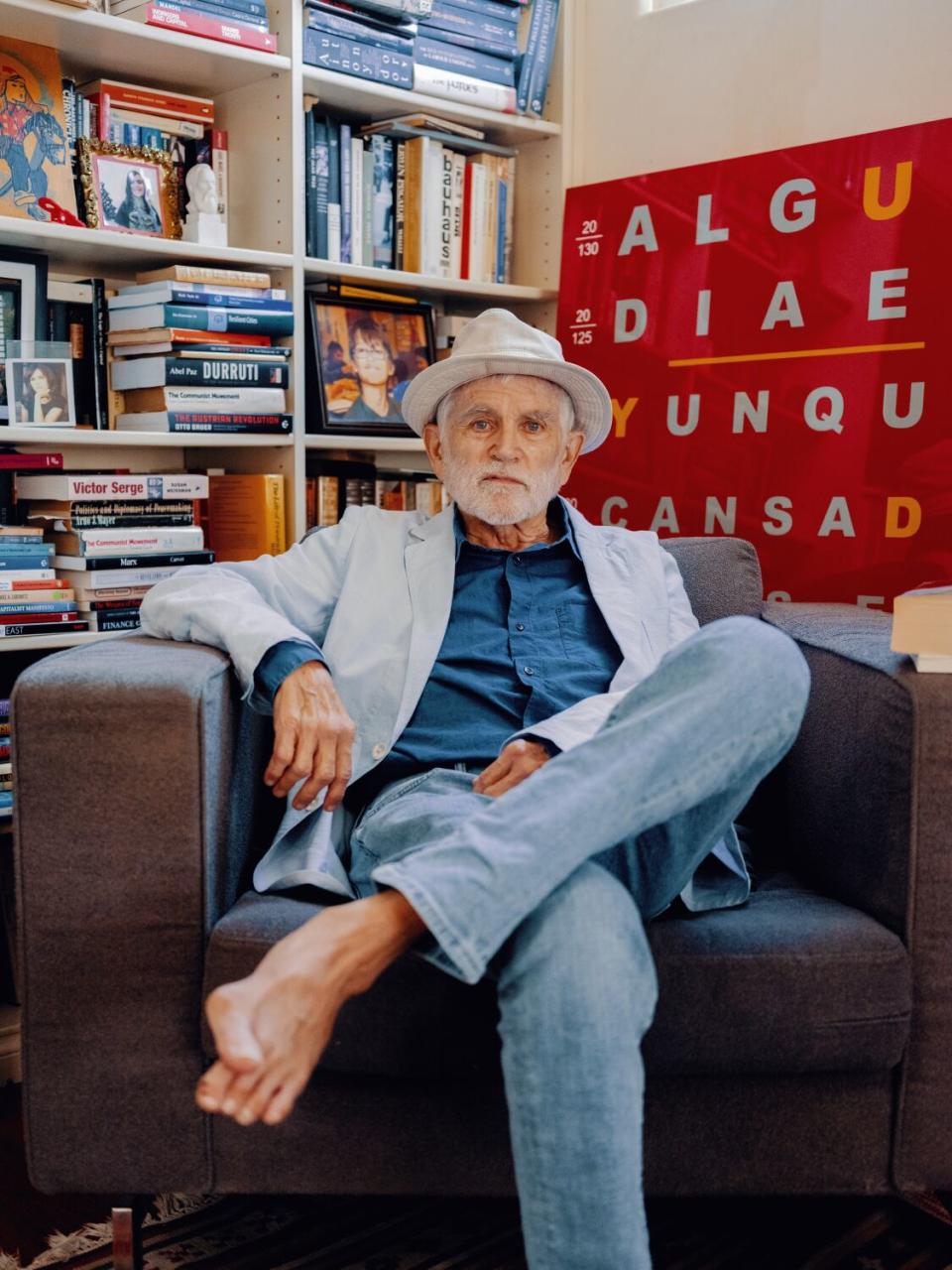 Mike Davis sits in his writing chair surrounded by books.