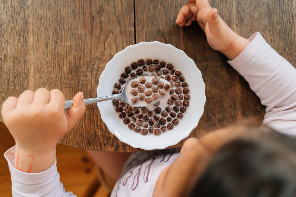 A young girl eating chocolate cereal