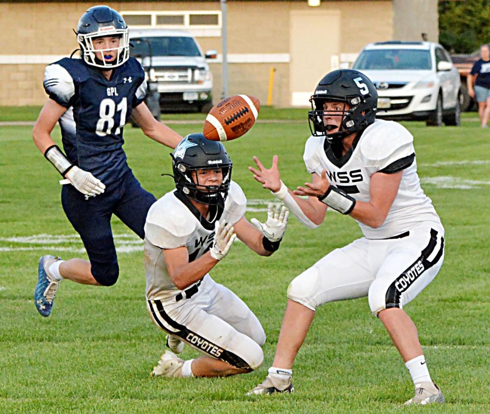 Waverly-South Shore's Evan Ekern (5) makes a catch in front of teammate Cody Thompson and Great Plains Lutheran's Alex Heil during their high school football game Friday night at Watertown Stadium. GPL won 31-22.