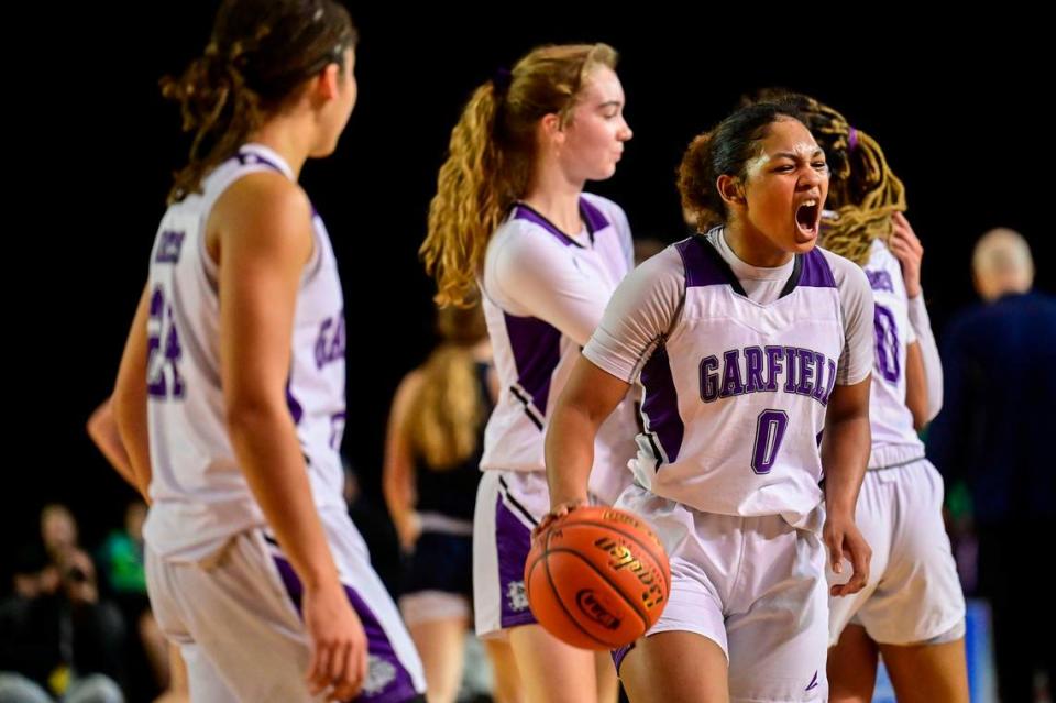 Garfield guard Malia Samuels (0) celebrates with teammates after beating Arlington, 56-42, in a Class 3A state tournament semifinal game on Friday, March 4, 2022, at the Tacoma Dome, in Tacoma, Wash.