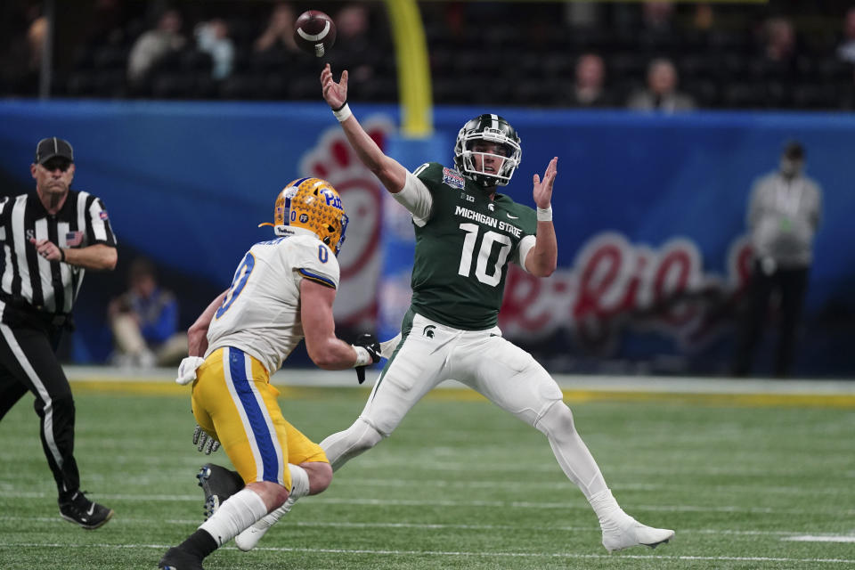 Michigan State quarterback Payton Thorne (10) passes the ball under pressure from Pittsburgh linebacker John Petrishen (0) during the second half of the Peach Bowl NCAA college football game, Thursday, Dec. 30, 2021, in Atlanta. (AP Photo/John Bazemore)