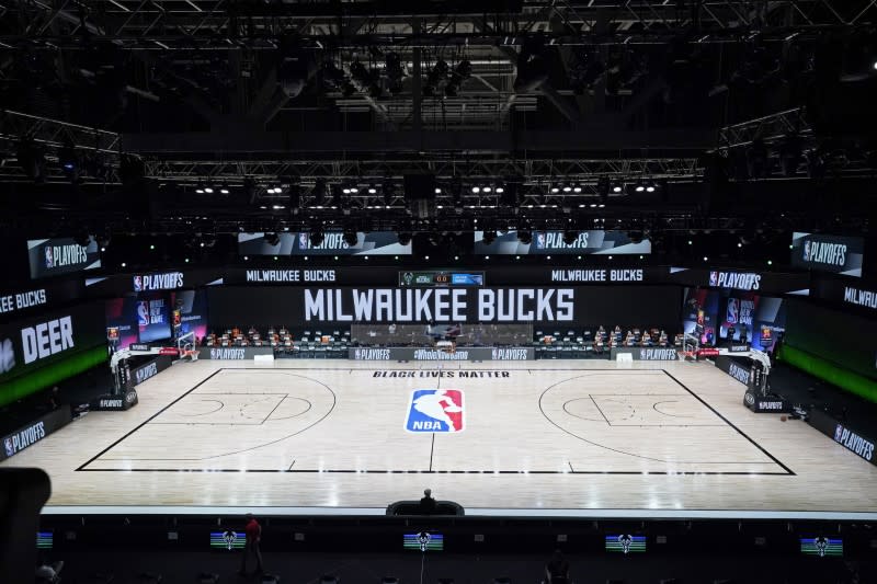 La cancha y las bancas vacías en el inicio de un juego programado de postemporada de baloncesto de la NBA entre los Milwaukee Bucks y los Orlando Magic, el miércoles 26 de agosto de 2020, en el Complejo Deportivo ESPN Wide World, en Lake Buena Vista, Florida, EEUU