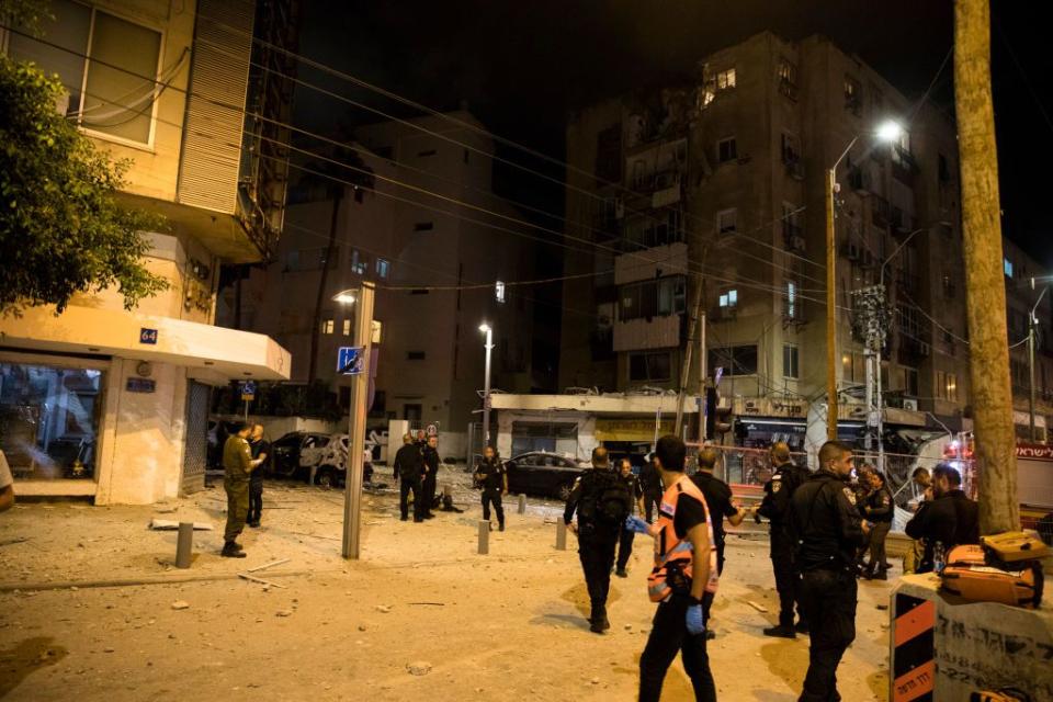 Israeli security forces work at the scene where a rocket fired from the Gaza Strip hit a building on Saturday in Tel Aviv.