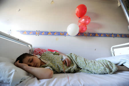 A boy sleeps while receiving treatment inside The Children's Hospital in Damascus, Syria February 20, 2017. Picture taken February 20, 2017. REUTERS/Omar Sanadiki