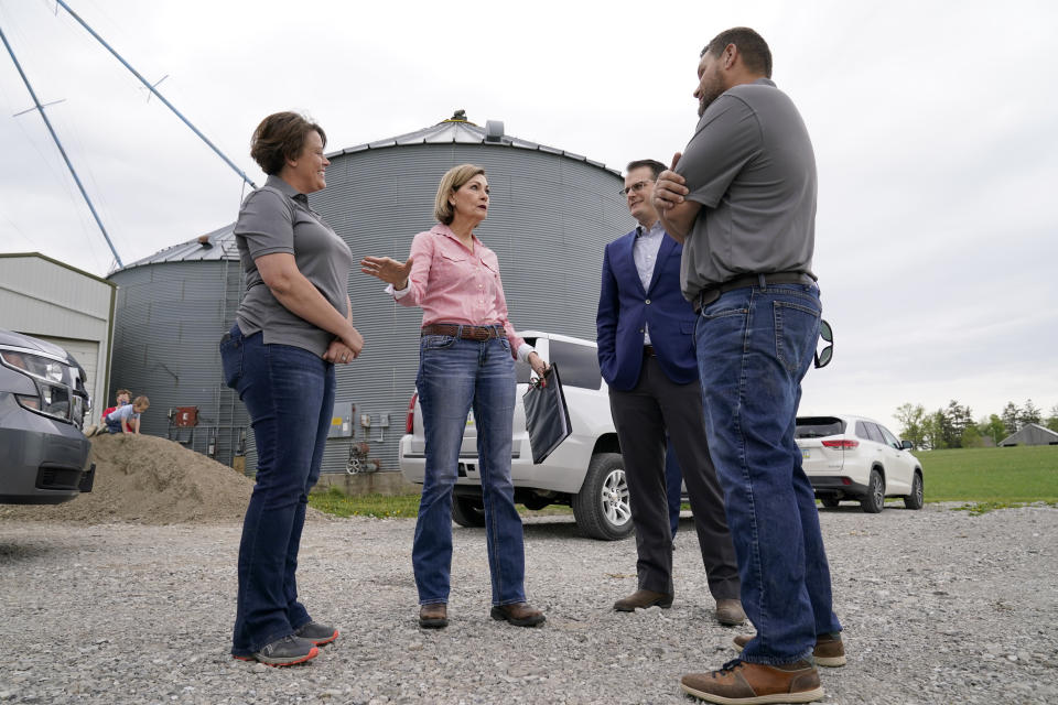 Iowa Gov. Kim Reynolds, center, talks with Cassie Cannon, left, Iowa Lt. Gov. Adam Gregg and Will Cannon, right, before signing the Biofuels Bill, Tuesday, May 17, 2022, in Prairie City, Iowa. (AP Photo/Charlie Neibergall)