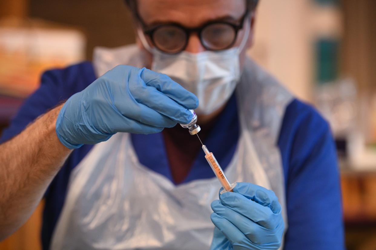 Doctor Tom McAnea prepares to administer the Oxford/AstraZeneca Covid-19 vaccine at a temporary vaccination centre in St Columba's Church in Sheffield, south Yorkshire on January 23, 2021. - Britain's Prime Minister Boris Johnson has revealed that 5.4 million people had now received their first dose of two vaccines currently being administered, with a daily record of 400,000 people inoculated in the last 24 hours. (Photo by Oli SCARFF / AFP) (Photo by OLI SCARFF/AFP via Getty Images)