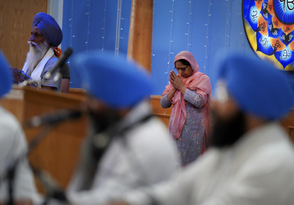 A woman prays as she walks around the sacred scripture during evening prayer at the Gurdwara Siri Guru Singh Sabha, a Sikh house of worship, in Edmonton, Alberta, on Wednesday, July 20, 2022. (AP Photo/Jessie Wardarski)