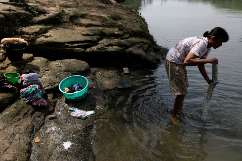 Eka Purwanti, a 37-year-old local, washes clothes at Cisadane river in Tangerang
