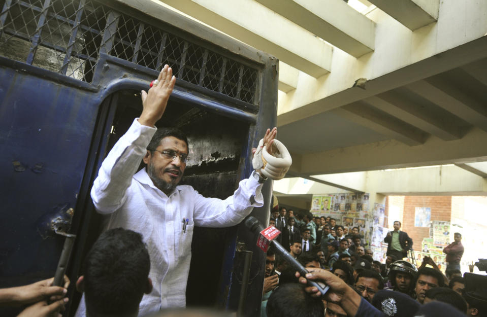 Lutfuzzoman Babar, a former junior minister for home affairs, speaks to the media as he enters a prison van at a court in Chittagong, Bangladesh, Thursday, Jan. 30, 2014. Babar was among 14 people sentenced to death on Thursday on charges of smuggling weapons to a rebel group in neighboring India. (AP Photo/Khurshed Rinku)