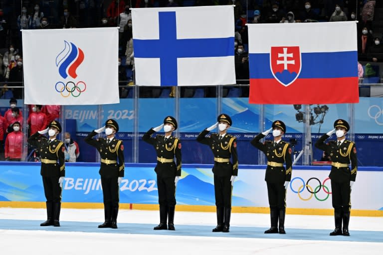 Aux Jeux d'hiver de Pékin en 2022, le drapeau russe est remplacé (à gauche) par un fanion olympique lors de la cérémonie des médailles du hockey sur glace, pour marquer l'exclusion de la Russie comme pays en raison de la guerre en Ukraine. (ANTHONY WALLACE)