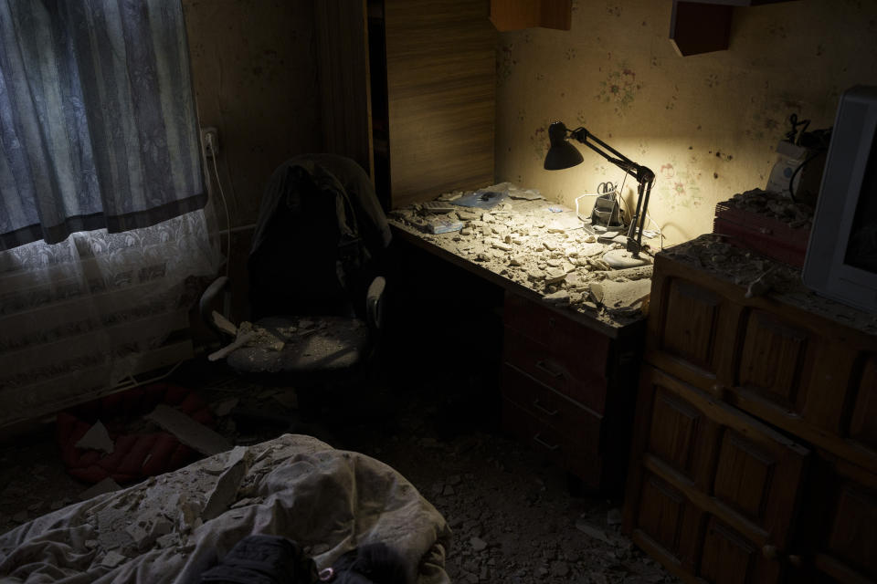 A bedroom is seen damaged after a Russian attack destroyed a building across the street, in Kharkiv, Ukraine, Tuesday, April 12, 2022. (AP Photo/Felipe Dana)