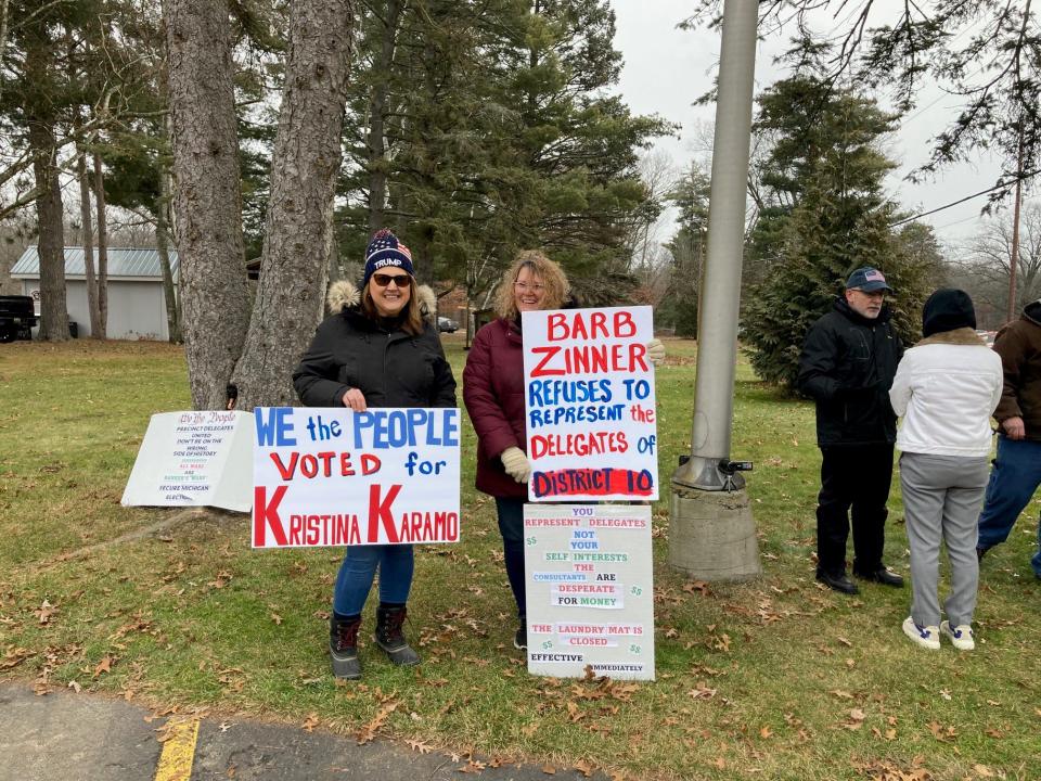 Supporters of Michigan Republican Party Chair Kristina Karamo protest Saturday outside of a meeting of state committee members considering Karamo's ouster. Holding signs, from left, are Melissa Pehlis, the Macomb County party secretary, and Michelle Lawler, of Brandon, who is a member of the executive committee in the 9th District. Both said Barb Zinner, the 10th District chair who is referenced in one of the signs, ignored appeals from party members to not participate in Saturday's meeting.