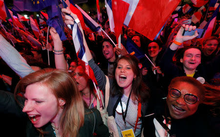 Supporters of Emmanuel Macron, head of the political movement En Marche !, or Onwards !, and candidate for the 2017 French presidential election, react after early results in the first round of 2017 French presidential election, in Paris, France, April 23, 2017. REUTERS/Philippe Wojazer