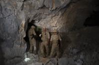 In this photo taken on Wednesday, Sept. 25, 2019, Russian military work inside caves that served as a major rebel base outside Latamna near the Syrian town of Khan Sheikhoun, Syria. The caves were dug by the rebels who controlled the area until it was captured by Syrian government troops last month. (AP Photo/Alexander Zemlianichenko)