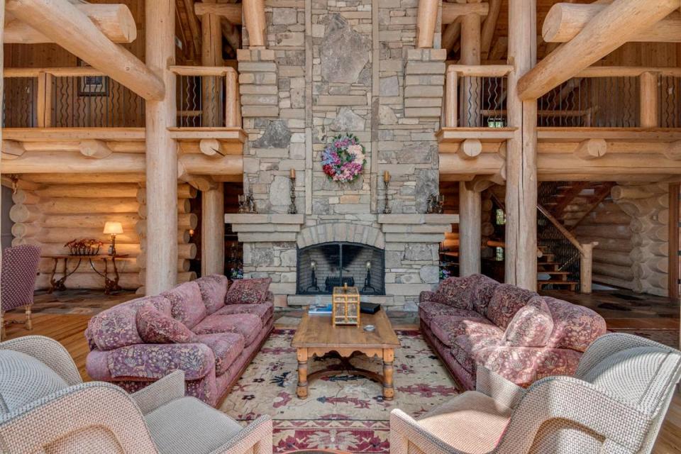 The living room area with fireplace of a $4.9 million log home for sale in South Carolina.