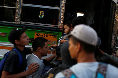 People board a bus in a caravan of migrants departing from El Salvador en route to the United States, in San Salvador March 30, 2019. REUTERS/Jose Cabezas