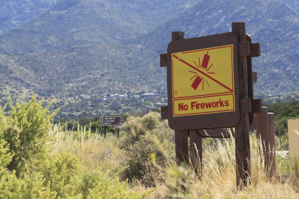 This June 30, 2023 image shows a sign prohibiting fireworks in the Sandia Mountains that border Albuquerque, New Mexico. U.S. Forest Service managers are urging people to use glow sticks and cans of aerosol party string as alternatives to fireworks, but some environmentalists say the string difficult to clean up and should not be used out in nature. (AP Photo/Susan Montoya Bryan)