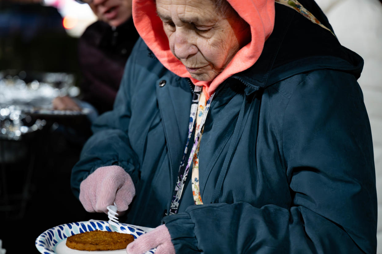 Rhoda Stein enjoys a Latkes topped with applesauce before the Menorah Lighting ceremony and “Great Chanukah Gelt Drop” at the Shops at Valley Square in Warrington Thursday night.