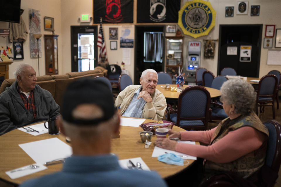 Pearl Harbor survivor and World War II Navy veteran David Russell, 101, center, talks with Karen Wilson, right, and other veterans while eating breakfast at the American Legion Post 10 on Monday, Nov. 22, 2021, in Albany, Ore. (AP Photo/Nathan Howard)