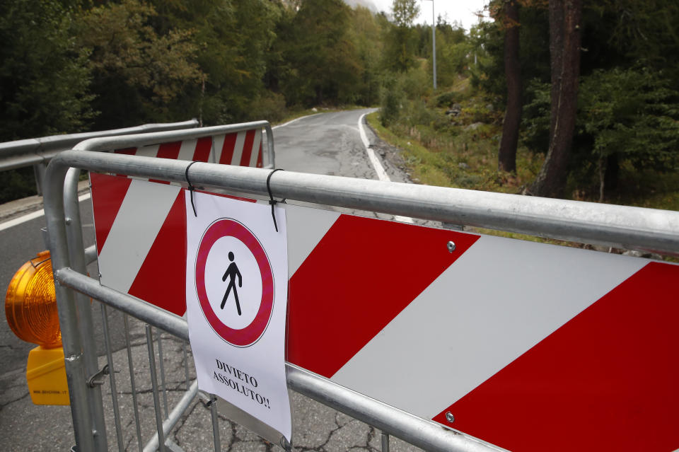 Barrier block a road that leads to the Planpincieux glacier, in the Alps on the Grande Jorasses peak of the Mont Blanc massif, above the Val Ferret, a popular hiking area on the south side of the Mont Blanc, near Courmayeur, northern Italy, Wednesday, Sept. 25, 2019. Italian officials sounded an alarm Wednesday over climate change due to the threat that the fast-moving melting glacier is posing to the picturesque valley near the Alpine town of Courmayeur. The glacier, which spreads 1,327 square kilometers (512 square miles) across the mountain, has been moving up to 50 centimeters (nearly 20 inches) a day (AP Photo/Antonio Calanni)