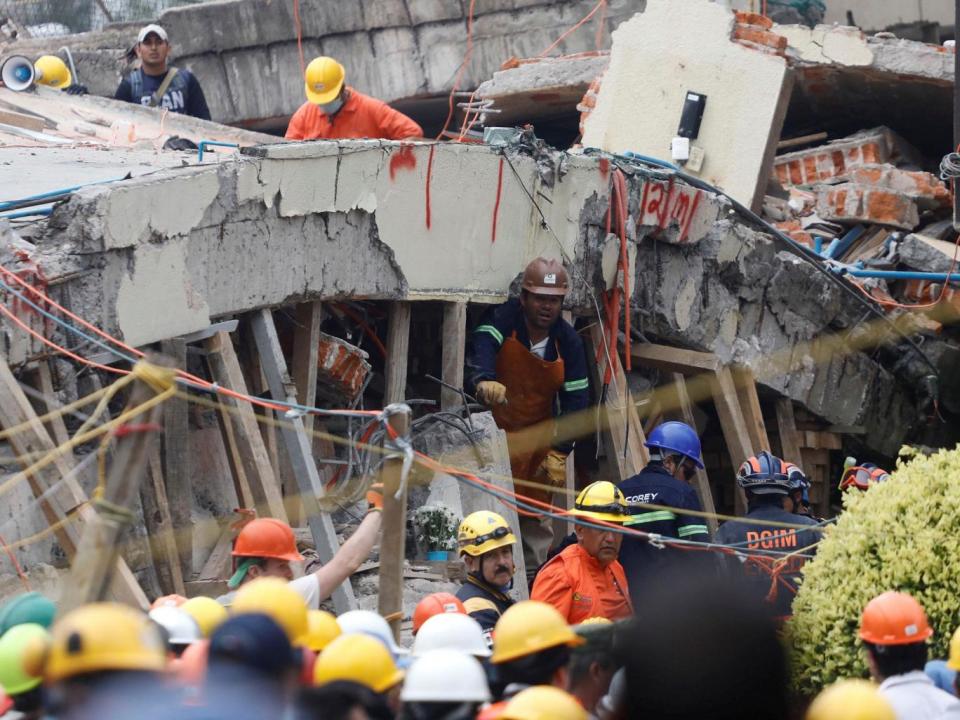 Rescue workers search through the rubble for students at Enrique Rebsamen school (Reuters)