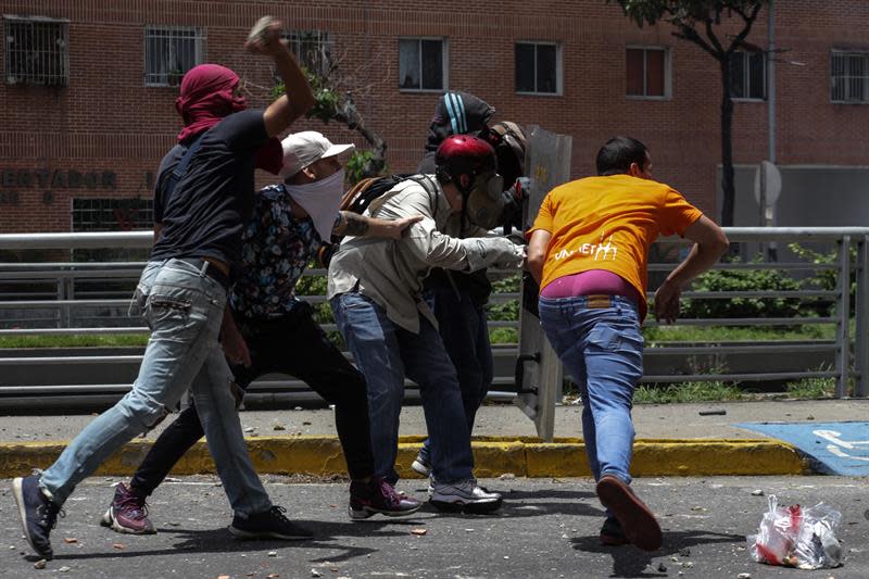 <p>Manifestantes opositores se enfrentan a integrantes de la Policía Nacional Bolivariana (PNB) durante una manifestación hoy, martes 4 de abril de 2017, que intentaba marchar hacia el Parlamento en apoyo a la destitución de los magistrados del Supremo, en Caracas (Venezuela). La Guardia Nacional Bolivariana de Venezuela (GNB, policía militar) disolvió hoy con gases lacrimógenos y perdigones de goma una manifestación de decenas de opositores que intentaban marchar hacia el Parlamento en apoyo a la destitución de los magistrados del Supremo, según constató Efe. EFE/CRISTIAN HERNÁNDEZ </p>