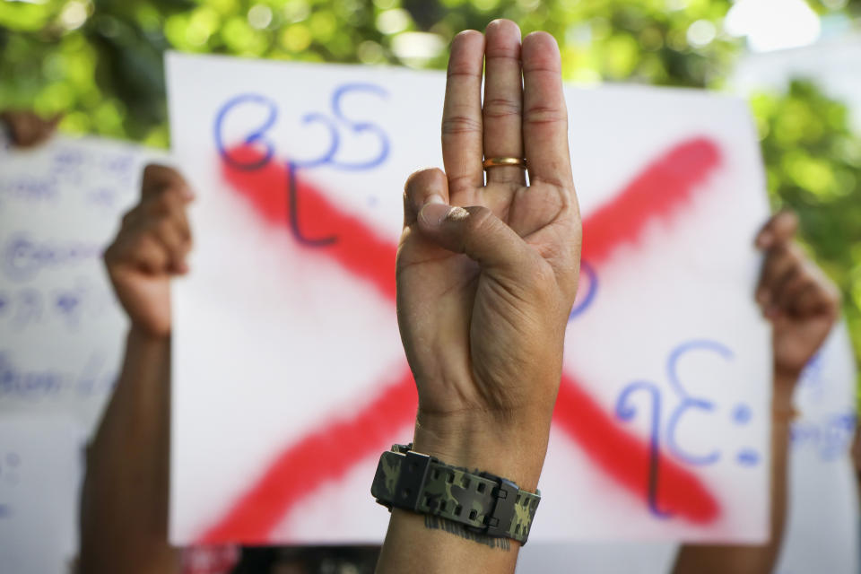 An anti-coup protester shows the three fingered salute of resistance during a strike walk with slogans to show their disaffection for military coup at neighborhood area of Hlaing township in Yangon, Myanmar, Friday, April 9, 2021. Threats of lethal violence and arrests of protesters have failed to suppress daily demonstrations across Myanmar demanding the military step down and reinstate the democratically elected government. (AP Photo)