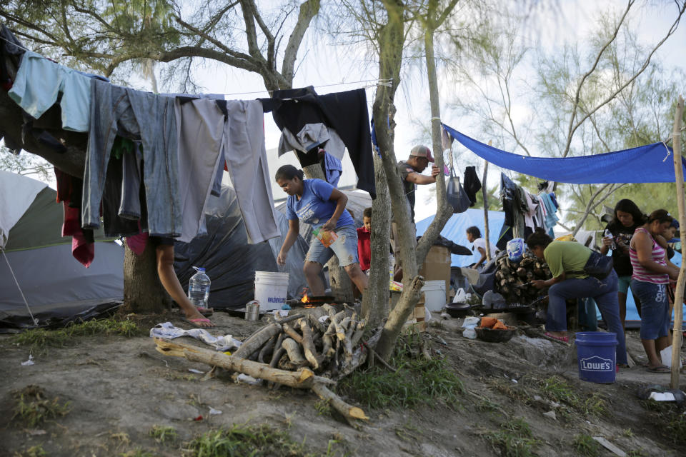 In this Tuesday, Nov. 5, 2019, photo, migrants live in a refugee camp in Matamoros, Mexico. One by one, asylum-seekers from El Salvador and Honduras who are waiting in Mexico for court hearings in the United States appeared before an immigration judge to explain why, after months of effort, they couldn't find an attorney. (AP Photo/Eric Gay, File)