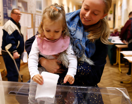 A woman with a child cast her vote during the Polish regional elections, at a polling station in Warsaw, Poland, October 21, 2018. REUTERS/Kacper Pempel