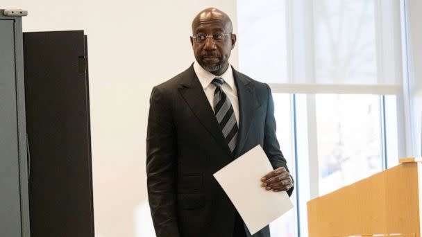 PHOTO: Sen. Raphael Warnock, D-Ga., carries his ballot during early voting Nov. 27, 2022, in Atlanta, in his runoff election against Republican Herschel Walker.  (Ben Gray/AP)