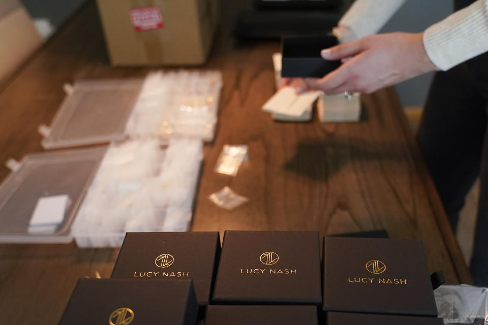 Hannah Nash places jewelry in a box that will be shipped out, Friday, Oct. 14, 2022, in Noblesville, Ind. Nash has her small business at her home. Small businesses are stocking the shelves early this holiday season and waiting to see how many gifts inflation-weary shoppers feel like giving. (AP Photo/Darron Cummings)