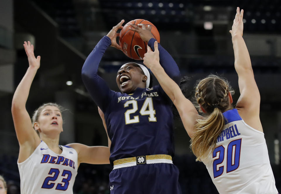 Notre Dame's Arike Ogunbowale, center, goes to the basket between DePaul's Dee Bekelja, left, and Kelly Campbell during the first half of an NCAA college basketball game, Saturday, Nov. 17, 2018, in Chicago. (AP Photo/Jim Young)