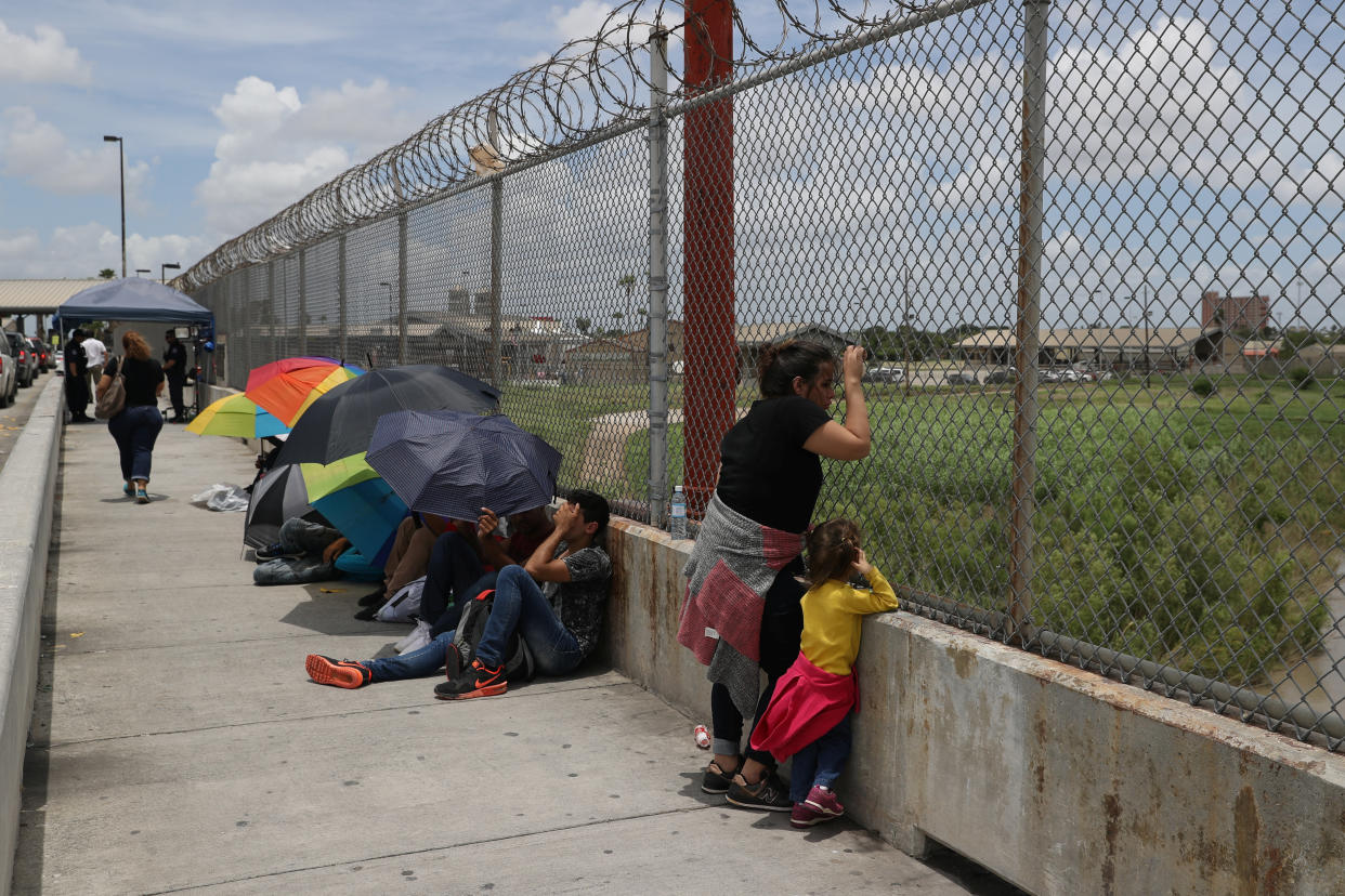 A Honduran mother and her 3-year-old daughter wait with fellow asylum-seekers on the Mexican side of the Brownsville-Matamoros International Bridge after being denied entry&nbsp;into the U.S. (Photo: Loren Elliott/Reuters)