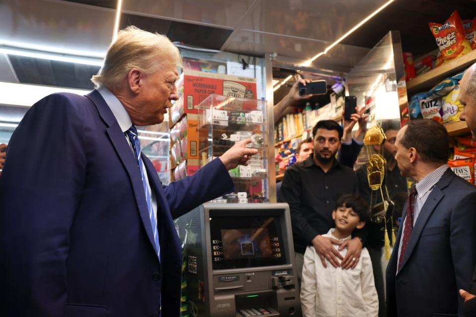 Mr Trump talks with the bodega’s owner Maad Ahmed yesterday (AP)