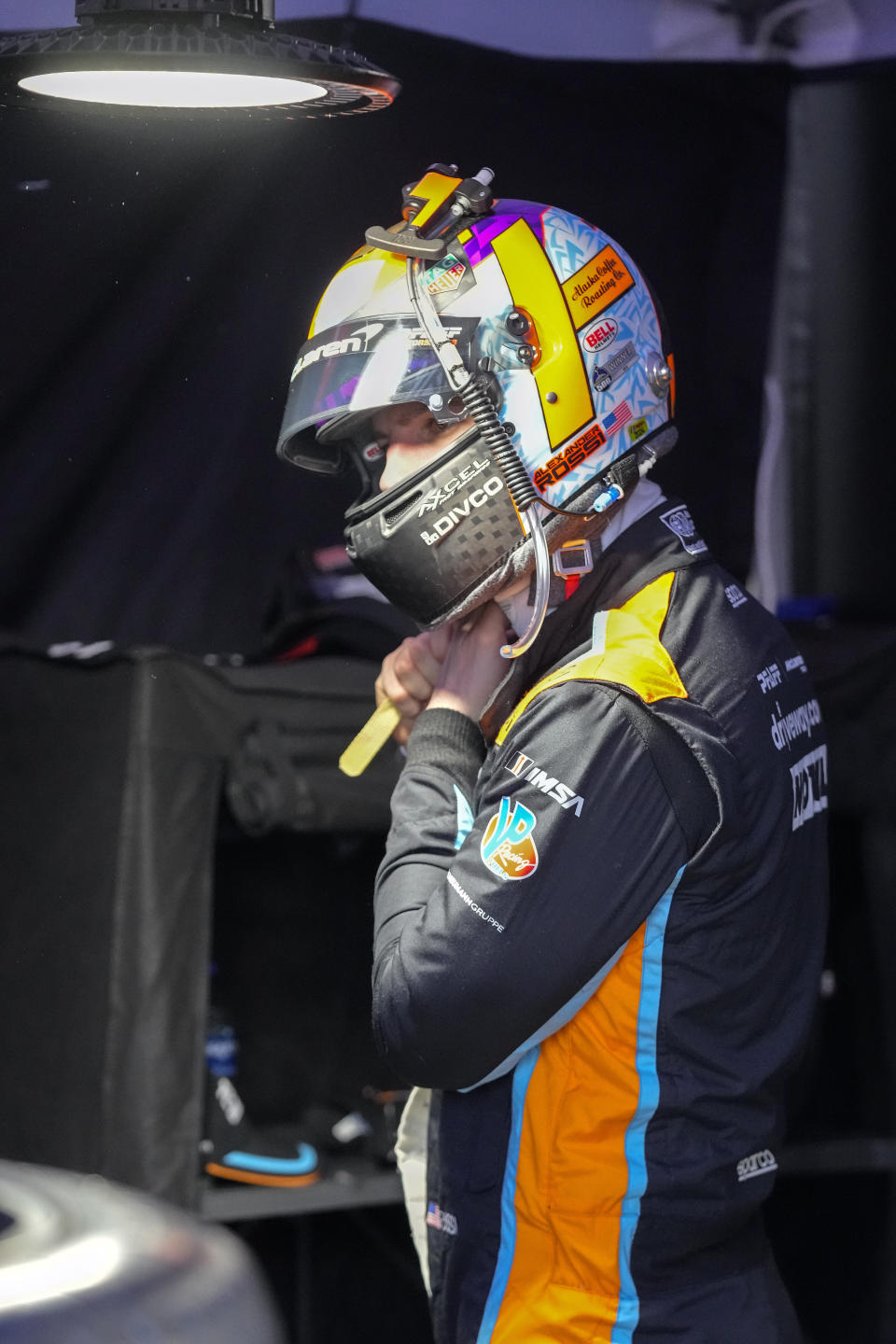 James Hinchcliffe prepares himself before getting in his car during a practice session for the Rolex 24 hour auto race at Daytona International Speedway, Thursday, Jan. 25, 2024, in Daytona Beach, Fla. (AP Photo/John Raoux)