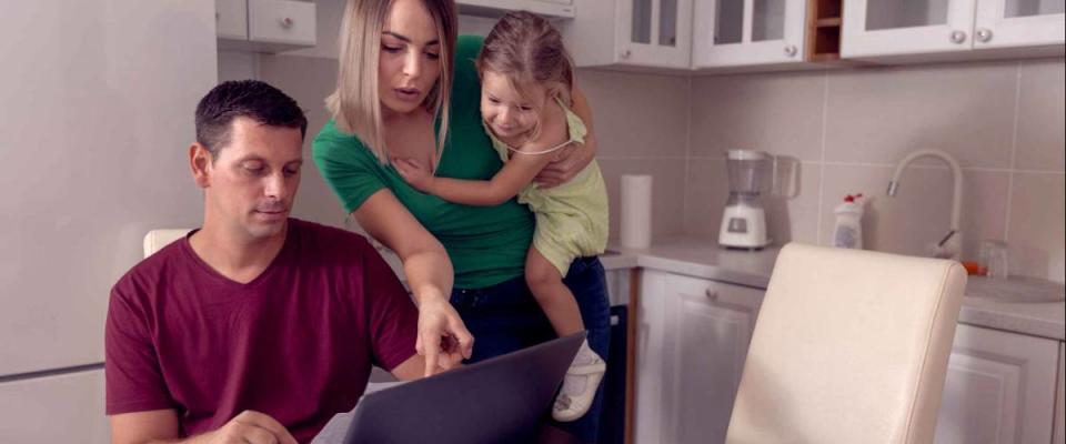 Worried young parent calculating bills at home