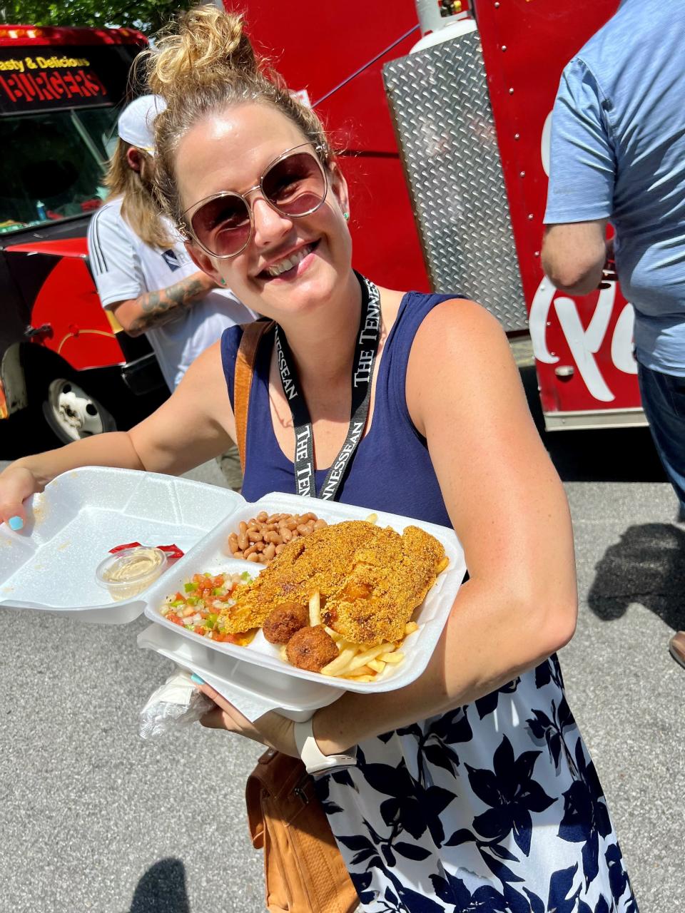 Tennessean food writer Mackensy Lunsford is loving a plate from Bob's Fish Fry food truck in downtown Nashville on July 6, 2023 as part of the weekly Street Eats lunchtime food trucks gathering