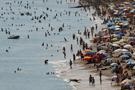 FILE PHOTO - Tourists enjoy the hot weather at Vari beach, some 30 km (19 miles) southeast of Athens July 21, 2013. REUTERS/Yannis Behrakis