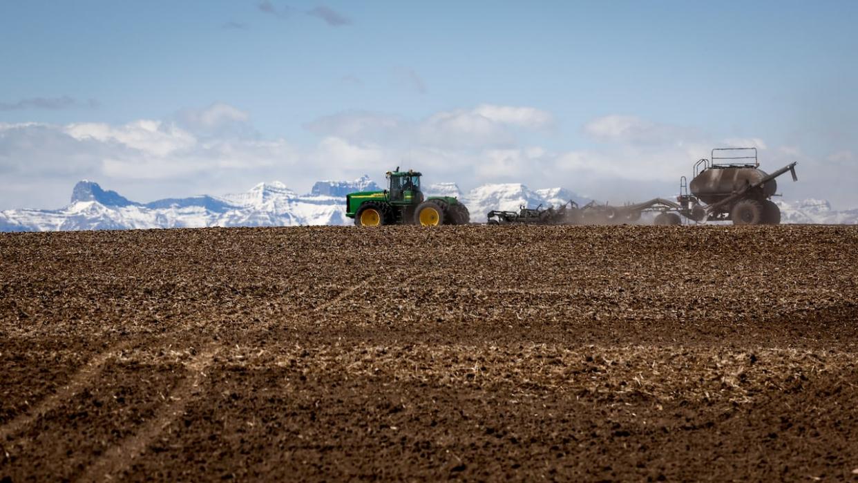 A family plants their wheat crop with a seeding rig, near Cremona, Alta., in a file photo from 2022. The Alberta government is promising $125 million over five years for a new drought and flood grant program. (Jeff McIntosh/The Canadian Press - image credit)