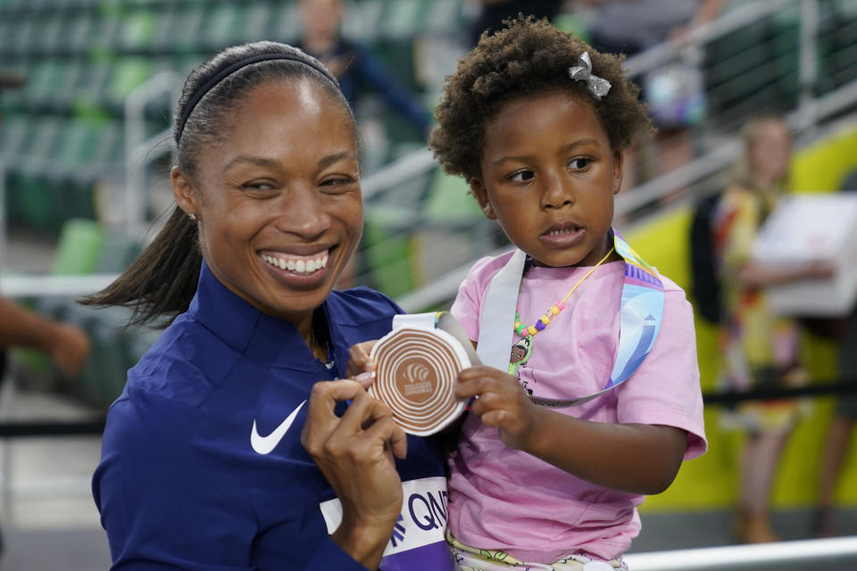 Allyson Felix, of the United States, gives her daughter Camryn her bronze medal after the 4x400-meter mixed relay final at the World Athletics Championships Friday, July 15, 2022, in Eugene, Ore. (AP Photo/Charlie Riedel)