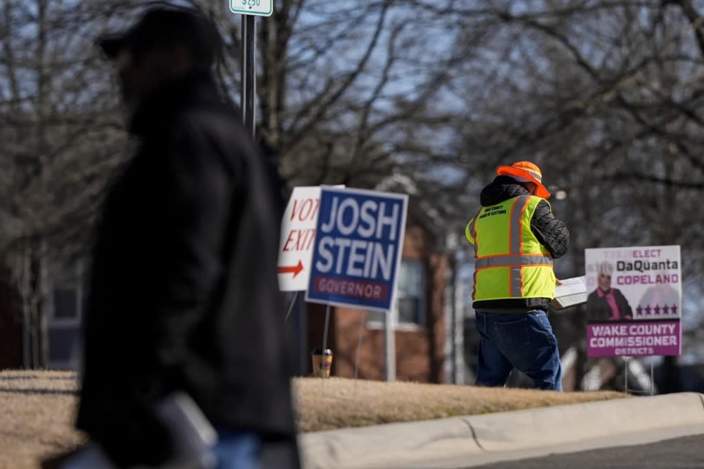 Election workers walk in the parking lot during early voting at the John Chavis Memorial Park Community Center, Wednesday, Feb. 21, 2024, in Raleigh, N.C. (AP Photo/Mike Stewart)
