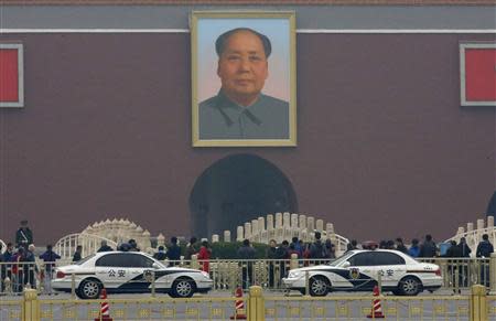 Police cars are parked in front of a giant portrait of late Chinese Chairman Mao Zedong at the main entrance of the Forbidden City in Beijing, November 1, 2013. REUTERS/Kim Kyung-Hoon