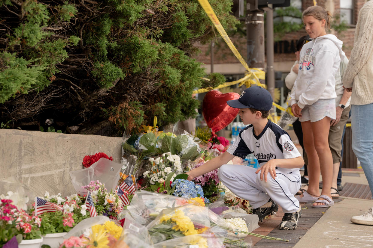 Personas en duelo visitan un sitio conmemorativo espontáneo cerca de la escena del tiroteo del desfile del 4 de julio en Highland Park, Illinois, el 6 de julio de 2022. (Mary Mathis/The New York Times)