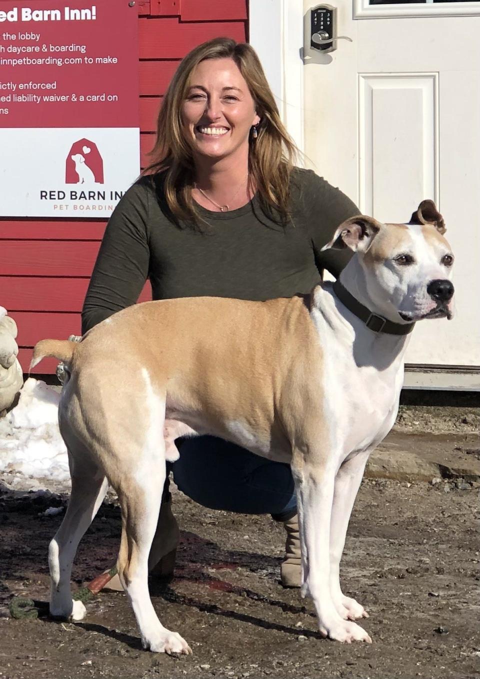 Audra Simpson is seen here with her boxer, Tucker, in front of the Red Barn Inn, the dog day care business that she owns on Alfred Road in Kennebunk, Maine, on Jan. 30, 2024.