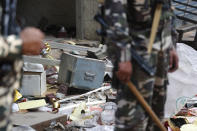 A safe of a shop lie outside after it was ransacked during riots as Indian paramilitary soldiers stand guard in New Delhi, India, Wednesday, Feb. 26, 2020. At least 20 people were killed in three days of clashes in New Delhi, with the death toll expected to rise as hospitals were overflowed with dozens of injured people, authorities said Wednesday. The clashes between Hindu mobs and Muslims protesting a contentious new citizenship law that fast-tracks naturalization for foreign-born religious minorities of all major faiths in South Asia except Islam escalated Tuesday. (AP Photo/Manish Swarup)