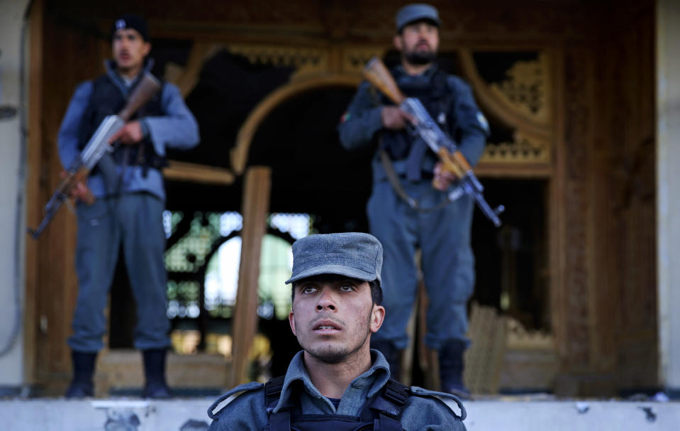 Afghan police stand guard in front of an Independent Elections Commission (IEC) building after a gun battle between security forces and insurgents in Kabul, Afghanistan, Tuesday, March 25, 2014. Gunmen stormed into the building, trapping dozens of employees inside and killing many people. A candidate for a seat on a provincial council was among those killed, along with an election worker, a civilian and a policeman. (AP Photo/Massoud Hossaini)