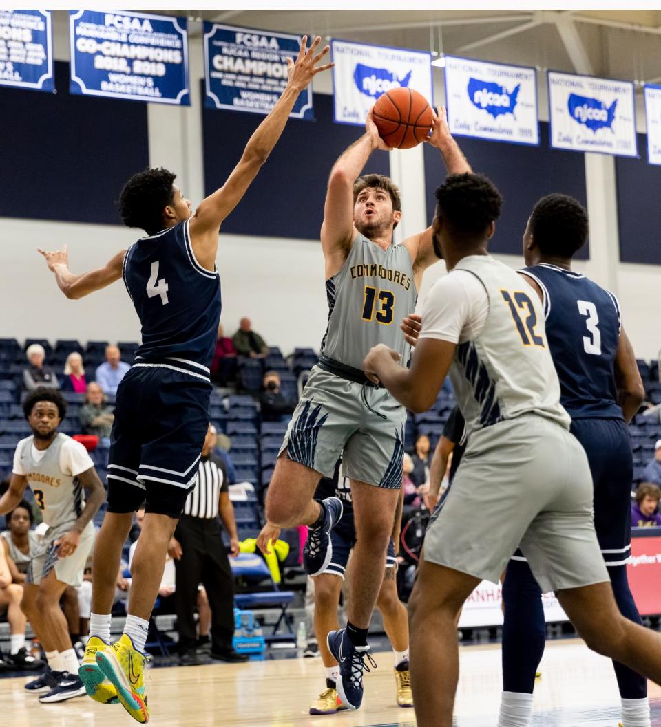 Kyle Murphy (13) goes up for a shot as Pensacola State's D'Anthony Pennington (4) tries to block the shot during a Panhandle Conference game at the Billy Harrison Field House on Saturday, Jan. 22, 2022.