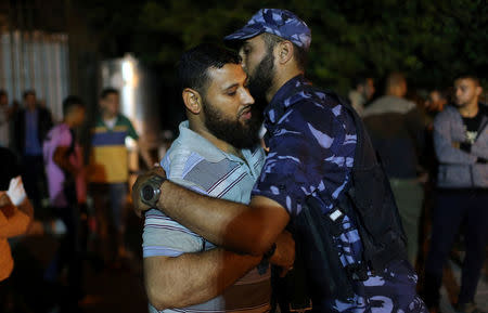 The brother of a Palestinian Hamas gunman, who was killed in an explosion, is consoled at a hospital in the central Gaza Strip May 5, 2018. REUTERS/Ibraheem Abu Mustafa